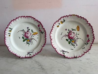 two plates with flowers on them on a table