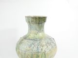 a green vase that is sitting on a white surface