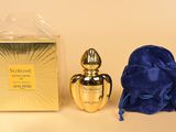 un gros plan sur un flacon de parfum à côté d'un sac bleu