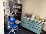 a blue chair in a room with a desk and shelves