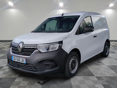 la camionnette blanche est garée dans une pièce au sol en damier