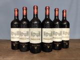six bottles of wine are lined up on a wooden table