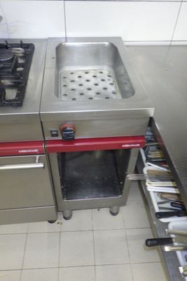 une cuisine équipée d'une cuisinière, d'un évier et d'autres appareils électroménagers