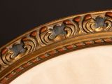a close up of a gold mirror with a black background