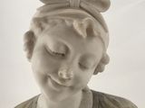 marble bust of a young girl with a bow on her head