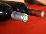 two bottles of wine sitting on a red cloth