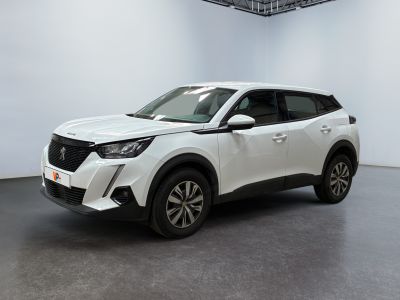 Le SUV blanc est garé dans une pièce blanche au sol noir.