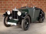 a green vintage car parked in front of a brick wall