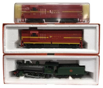 deux wagons rouges et verts dans une boîte posée sur une surface blanche
