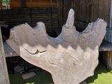 a large stone sculpture of a hand on a green lawn