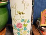 un vase avec un oiseau posé sur une table
