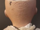 a clay doll with a lace collar around it ' s neck