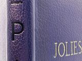 purple book with gold lettering on it sitting on a white surface