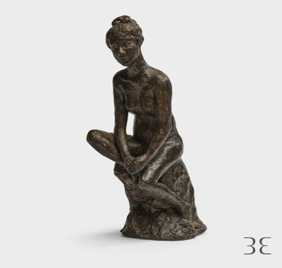 une statue représentant une femme assise sur un rocher, les mains posées sur les genoux