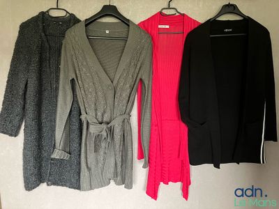 trois pulls pour femme accrochés à un mur, alignés les uns à côté des autres