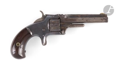 un vieux revolver avec un manche en bois sur fond blanc