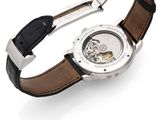 a close up of a watch on a white surface with a black strap