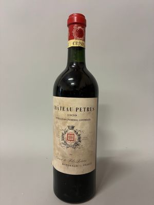 une vieille bouteille de vin posée sur une table blanche