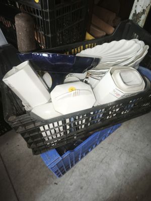 a basket full of dishes and cups on the floor
