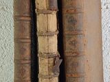two old books stacked on top of each other on a table