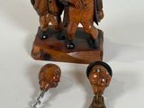 a wooden figurine of two people and a bottle opener