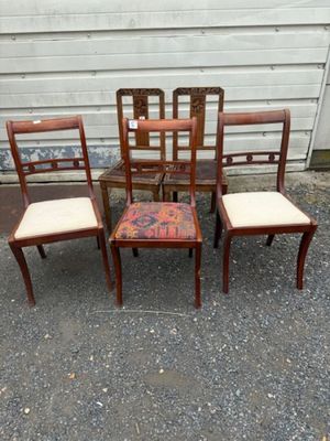 quatre chaises et une table devant un mur blanc