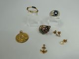plusieurs bagues et boucles d'oreilles différentes exposées sur un fond blanc