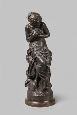 une statue en bronze d'une femme assise sur un rocher