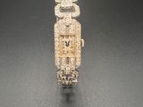 une image représentant une montre en or et diamants posée sur un fond noir