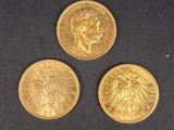 trois types différents de pièces d'or posées sur une surface noire