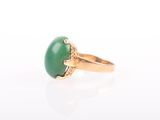 a close up of a ring with a green stone on it