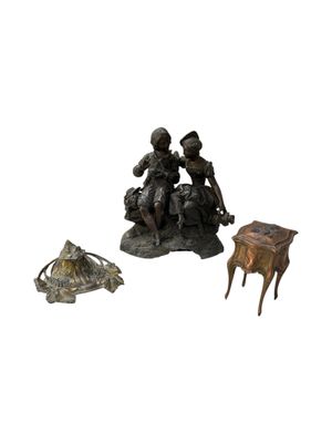 a statue of a man sitting on a stool next to a small table