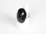 a close up of a ring with a black stone on it