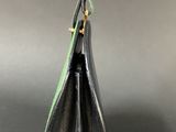 a small black vase with a green ribbon in it