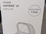 Le carton de la poussette est posé par terre dans le magasin.