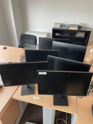 quatre écrans d'ordinateur posés sur un bureau dans un bureau