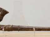 a bronze pipe with a man sitting on top of it