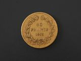 a close up of a gold coin on a black surface