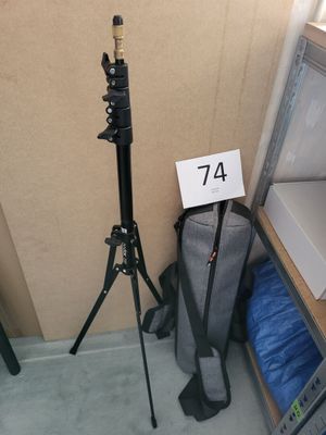un trépied sur lequel est posé un panneau, à côté d'un sac