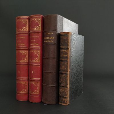 three books are stacked on top of each other on a black surface