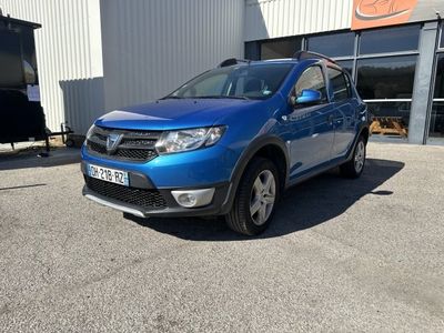 une Dacia bleue garée devant un immeuble