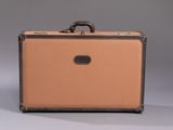 an old suitcase with a handle is sitting on a gray surface