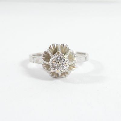 une image d'une bague en diamant sur une surface blanche