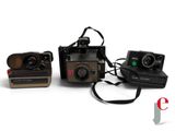 three polaroid cameras sitting next to each other on a white surface