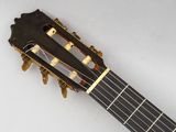 a close up of an acoustic guitar on a white surface