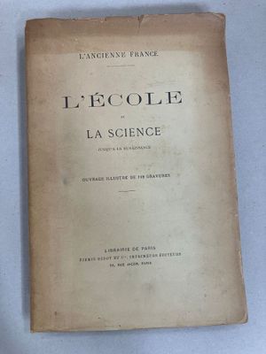 un vieux livre posé sur une table à côté d'une tasse de café