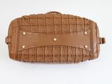 brown leather handbag on a white surface with a white background