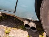 a close up of a car exhaust pipe on the side of the road