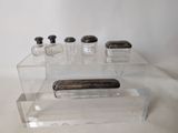 clear acrylic display case with three bottles and a soap dispenser