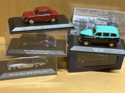 four model cars are displayed in a display case on a table